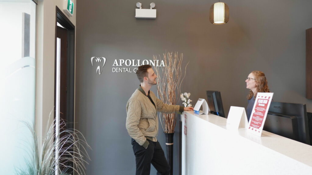 Dental assistant welcoming a patient for implant surgery at Apollonia Dental Clinic
