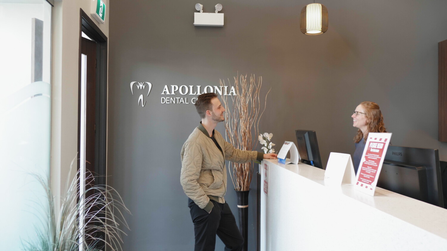 Dental assistant welcoming a patient for implant surgery at Apollonia Dental Clinic
